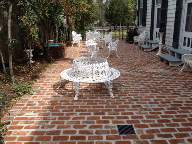 Brick courtyard with white iron furniture and fountain