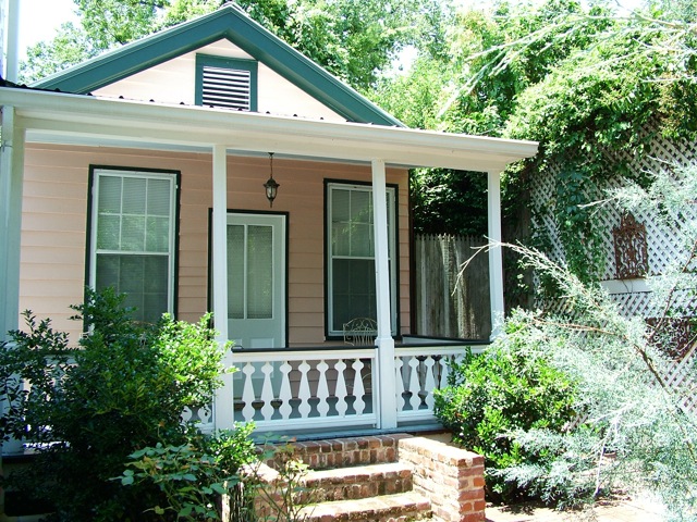 The pink guest cottage at Stone House, front porch with white balustrade