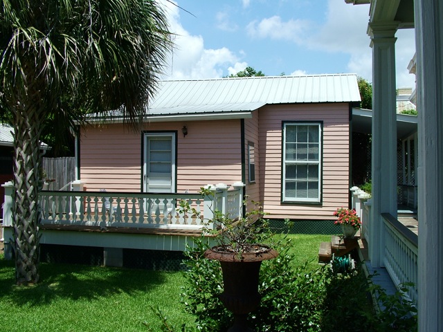 The guest cottage side deck with palm tree and lawn