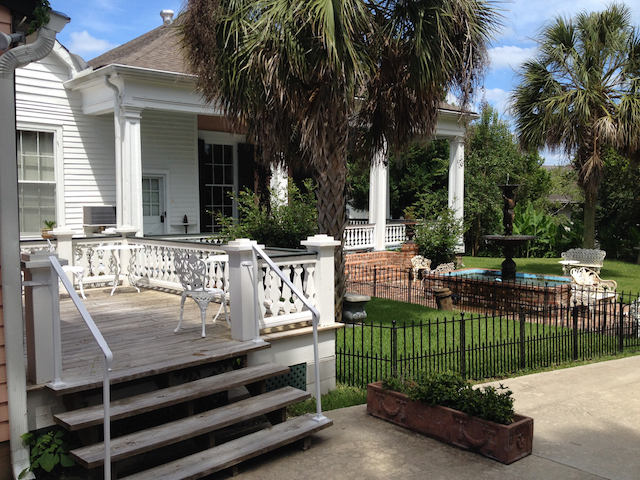 Guest cottage side with deck steps and fountain beyond